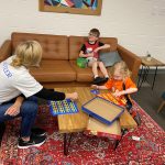 Volunteer with two children playing games